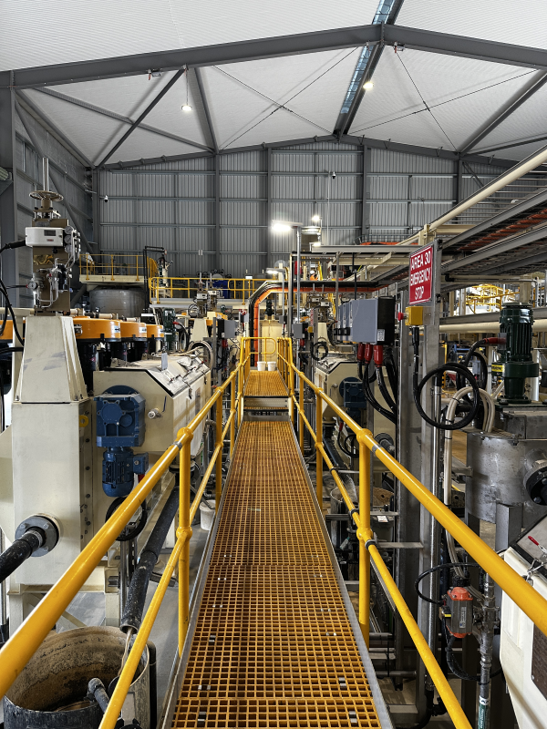 A yellow walkway running through a large industrial testing facility inside a warehouse
